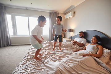 Image showing Mother, father and children jump on bed or bedroom and wake up happy together in family home in the morning. Happiness, love and smile of kids with parents in a house for real estate or holiday
