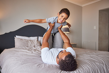 Image showing Smile, love and happy father and son family time playing in bedroom bed lifting him like airplane or superhero. Loving dad, man or single parent bonding with cheerful kid in the morning at home.