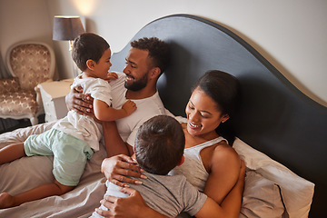 Image showing Children, bed and happy family in a bedroom in the morning, having fun and bonding while hug and playing together. Parents embracing their boys, enjoying a lazy day and sharing playful moment