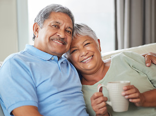 Image showing Love, hug and sofa with senior couple relaxing and bonding in their living room at home. Portrait of a happy mature man and woman sitting on couch in a lounge while embracing each other with a smile.