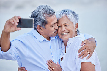 Image showing Love, senior couple taking phone selfie and smile, happy together and kiss for picture or video. Man and woman living retirement lifestyle take photograph with digital smartphone on romantic date