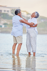 Image showing Beach dance, senior couple and comic man and woman standing in sea or ocean water and hugging at sunset. Happy, smile and bonding for marriage anniversary and love while dancing in nature with trust