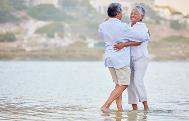 Image showing Landscape, beach and dance of a senior couple smiling and dancing in the sea or ocean water and hugging at sunset. Happy, smile or bonding of an old man and woman dancing in nature for marriage.