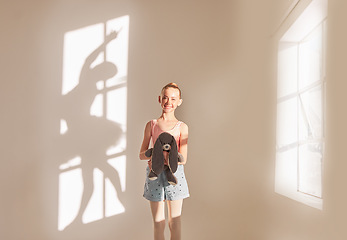 Image showing Creative art and dance with a girl dreaming of ballet with motivation and goal of becoming dancer in a studio with a teddy bear. Shadow of a ballerina or dancer on a wall with a kid next to a window