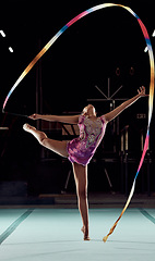 Image showing Ribbon gymnastics, exercise and sports girl performing a routine in a professional gym arena. Fitness, flexibility and creative woman training balance, agility and strength for a competition show.