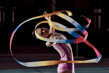 Image showing Woman dancing with ribbon in concert in arena, dancer doing creative, artistic and cardio dance and training a performance in dark studio. Girl gymnast doing sport workout and strong in competition
