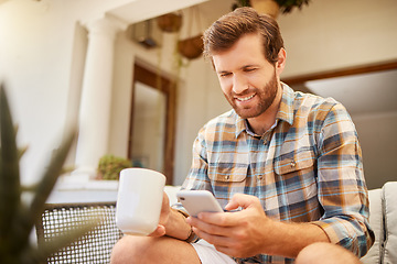 Image showing Phone, coffee and communication with a man on a social media app and mobile technology at home. Tea, relax and internet with a young male reading and typing a message while sitting in the living room
