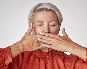 Image showing Senior, hands and mouth of an elderly woman covering her teeth or lips with hand against a grey studio background. Mature and aging woman keeping secrets, not talking and hiding the truth or gossip.