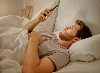 Image showing Social media, mobile app and relax man with smartphone using the internet or online website content at night in his bedroom with home wifi. Serious insomnia person reading blog for sleep health tips