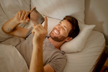 Image showing Phone, 5g technology and mobile internet with a young man streaming movies and lying in bed in his bedroom at home in the morning. Relax and enjoy online entertainment and subscription service