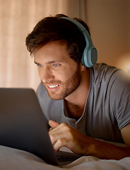 Image showing Laptop, online tv and movie subscription with headphones late at night in his bedroom. Man with insomnia distracted with steaming internet to watch film, esports or enjoy gaming to relax at home