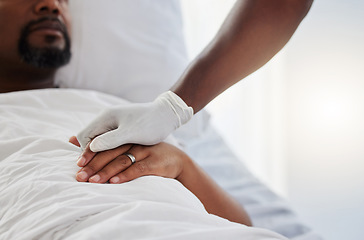 Image showing Cancer, death and medical support with a patient and nurse in a hospital for health, wellness and love. Closeup of the hand of a doctor giving comfort and care to a man lying in a clinic bed