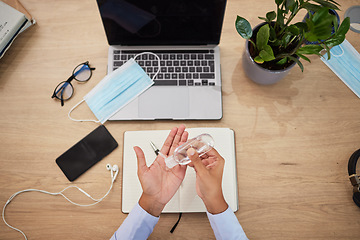 Image showing Covid, sanitizer and personal safety with a business person or employee sanitizing hands and working at a desk in an office. Healthcare, hygiene and cleaning at work during the corona virus pandemic