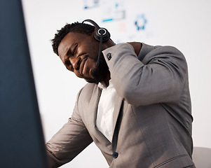 Image showing Stressed, pain and tired call center agent with a shoulder injury feeling unhappy and overworked in the office. Young male customer service consultant with suffering from a painful neck