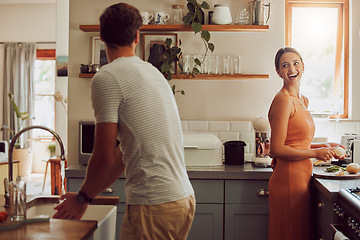 Image showing Couple cooking food, household cleaning or food preparation together in their kitchen at home. Laughing, bonding and caring husband and wife helping each other prepare supper, lunch or meal