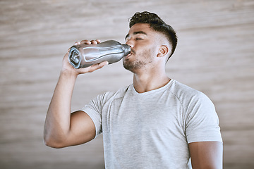 Image showing Fitness runner after training, healthy drinking water from bottle and strong athletic young man takes a break from running. Workout motivation, wellness exercise and natural sports lifestyle