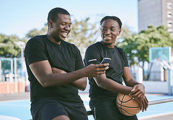 Image showing Male brothers on their phone spending time together, siblings or friends bonding as a family outdoors. Relaxing, smiling and taking breaks from African American men after playing basketball.