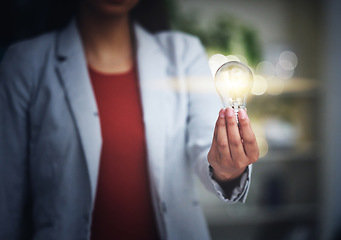 Image showing Light bulb, innovation and bright idea with vision, strategy and growth mindset for startup. Closeup hand of leading, thinking and motivated business woman holding lightbulb and showing knowledge