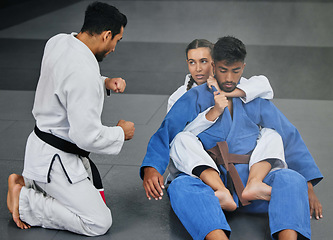 Image showing Karate training with trainer at a fitness studio, learning defense moves and practising fighting for competition together at a gym. Serious, active and fit woman doing routine judo workout at club