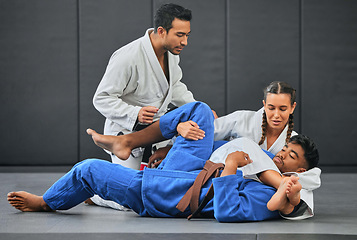 Image showing Mma, martial arts and exercise with a coach, teacher or instructor instructing students during practice, training or sparring in a gym or dojo. Fighting and self defense class for health and fitness