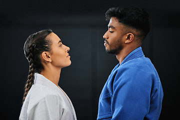 Image showing Mma, martial arts and self defense training or practice with a man and woman having a face off in studio against a black background. Man and woman in gi or uniform ready to fight in combat sport