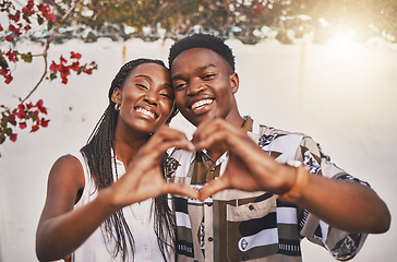 Image showing Happy couple heart love sign with their hands posing for a picture or photo while on vacation or holiday. Portrait of a loving and young African American lovers having fun together smiling in joy