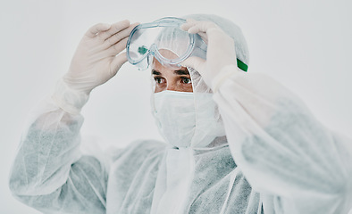 Image showing Covid, healthcare worker with safety protection clothing during first virus outbreak. A medical research professional in a hazmat suit and goggles preparing for work and staying safe during pandemic