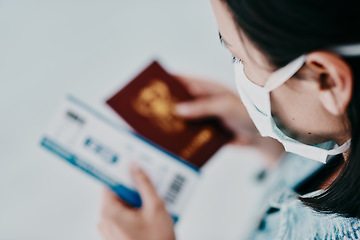 Image showing A woman traveling during the covid pandemic holding her passport and flight ticket at the airport. A tourist leaving the country due to the ease of travel restrictions during the coronavirus pandemic