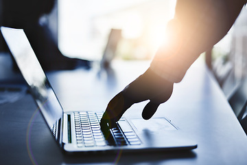 Image showing Hand typing on a laptop during a business meeting in a dark office or boardroom. Closeup silhouette of a corporate professional using a computer and browsing the internet or sending an email