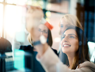 Image showing Smiling business woman working on teamwork success and meeting collaboration and writing on colorful notes. Successful female office worker making notes on a board. Marketing team planning a strategy