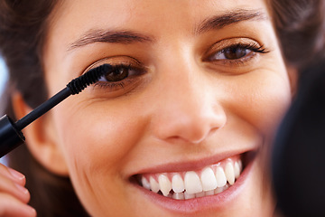 Image showing Face, beauty and lashes with a woman applying mascara to her face for cosmetic treatment and confidence. Closeup headshot of a female looking happy and positive with her skin and eyes closeup