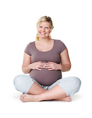 Image showing Pregnant, happy and healthy woman sitting with her hands on her stomach while enjoying her pregnancy against a white background. Health, wellness and hope of a mother to be ready for childbirth