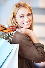 Image showing Fashion, sale and shopping woman or customer is happy and excited holding bags at a store. Discount, offer and deal for smiling female in retail shop at the mall spending money on style at an outlet