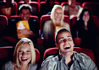 Image showing Couple at cinema movie theatre for funny, comic and happy film show in audience auditorium on a date. Smile, relax and laughing people watching comedy movies on big screen in a dark theater together