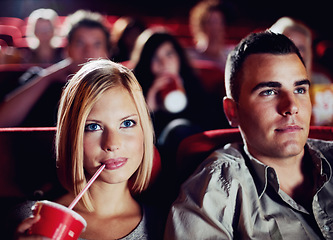 Image showing Couple in dark movie theatre, drinking cola on date in cinema and man and woman watching a film together for entertainment. Face of happy, dating and fun boyfriend and girlfriend at the movies