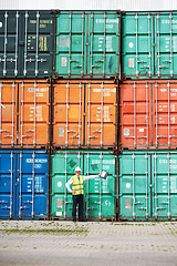 Image showing Logistics worker in shipping or manager of container store at a port, working in safety at global sea freight transport business. Cargo ready for international delivery, export and commercial trade.