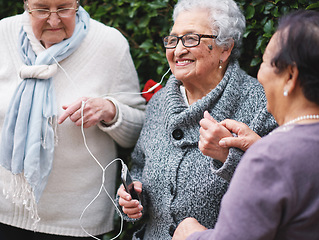 Image showing Happy old women listening to music on smartphone wearing earphones smiling enjoying fun celebrating retirement together outdoors