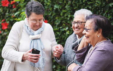 Image showing Funny elderly women listening to music on smartphone wearing earphones smiling enjoying fun celebrating retirement together outdoors