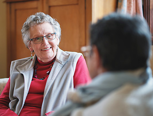 Image showing Happy elderly woman talking to friend sitting on sofa in retirement home having conversation