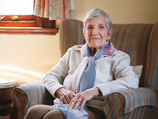 Image showing Happy elderly woman smiling sitting on sofa at home enjoying retirement