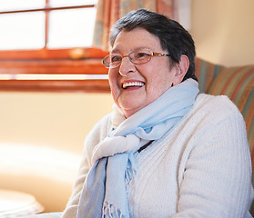 Image showing Happy elderly woman laughing sitting on sofa at home enjoying retirement