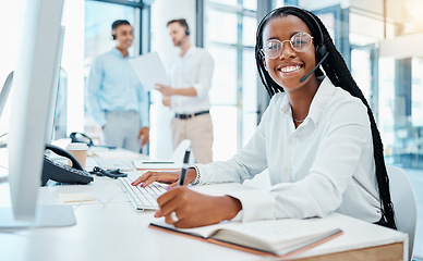 Image showing Contact us, crm and online support by call center agent writing note and help customer in office. Smiling black operator enjoy communication and giving expert advice, being friendly and professional