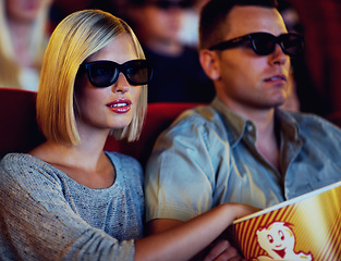 Image showing Couple, 3D movie and cinema of a man and woman sitting and eating popcorn together wearing glasses. People in a relationship watching a film in a theatre for indoor entertainment while having snacks.