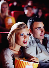 Image showing Film, cinema and couple love popcorn at the movie theatre at night in a dark room for horror, action and scary entertainment. People, man and young woman watching romantic comedy together on date