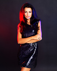 Image showing Glamour, style and a confident woman looking cool in an evening dress against a dark, black background. Proud female standing in a power pose, feeling elegant and feminine with a party girl attitude