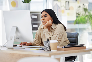 Image showing A bored, lazy and tired employee working on a computer in the office leaning on her desk. An overworked business woman is annoyed and frustrated by her job sitting at her table feeling burnout