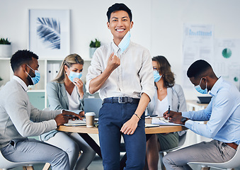 Image showing Meeting, partnership or collaboration by business people during covid in an office planning. Portrait of an Asian male corporate employee happy to remove a coronavirus face mask at end of a pandemic