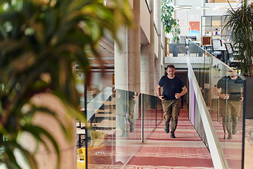 Image showing In the hustle and bustle of a modern startup office, a determined businessman sprints towards his office, embodying the fast-paced, ambitious spirit of contemporary entrepreneurship