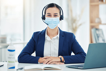 Image showing Compliance, face mask and covid regulations at a call center by woman working in customer service on a laptop. Portrait of a happy online operator, health and safety awareness and social distancing