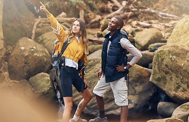 Image showing Fitness hiking, nature and couple in exercise workout together looking at paths to take on a rocky trail in the outdoors. Interracial man and woman pointing for motivation and navigation during hike.